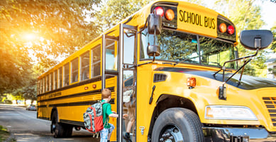 Child boarding yellow school bus 