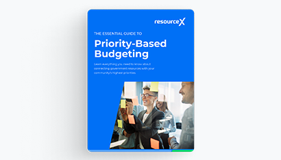 Cover image of the Priority-Based Budgeting 101 E-Book, Colleagues in a conference room collaborating using sticky notes on a modern glass wall