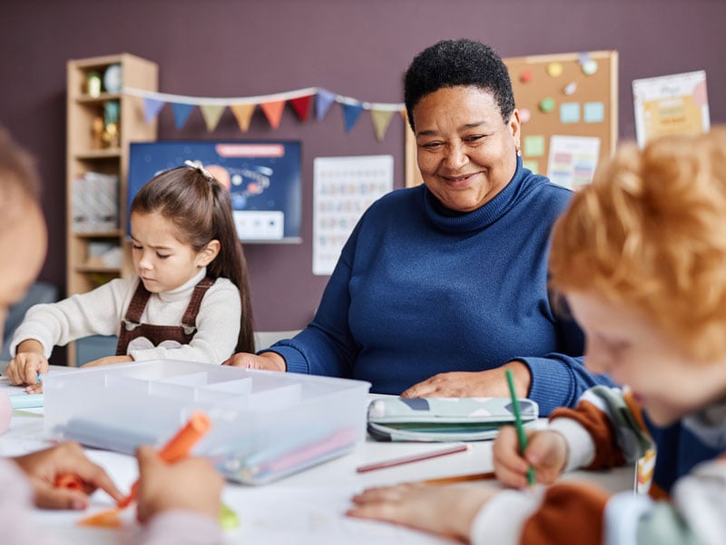pre-school teacher with students in classroom