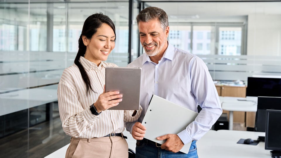 Two employees collaborating while using a tablet