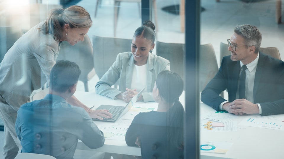 group of professionals meeting in conference room to discuss budgets