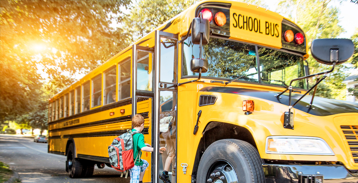 Child boarding yellow school bus 