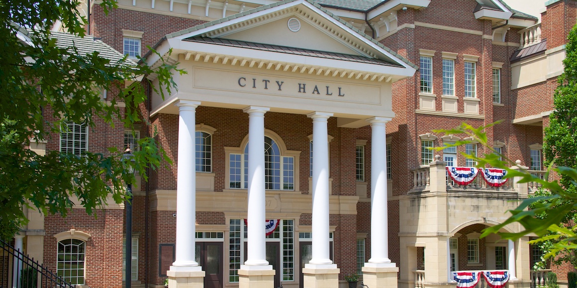 City Hall building with columns and flags