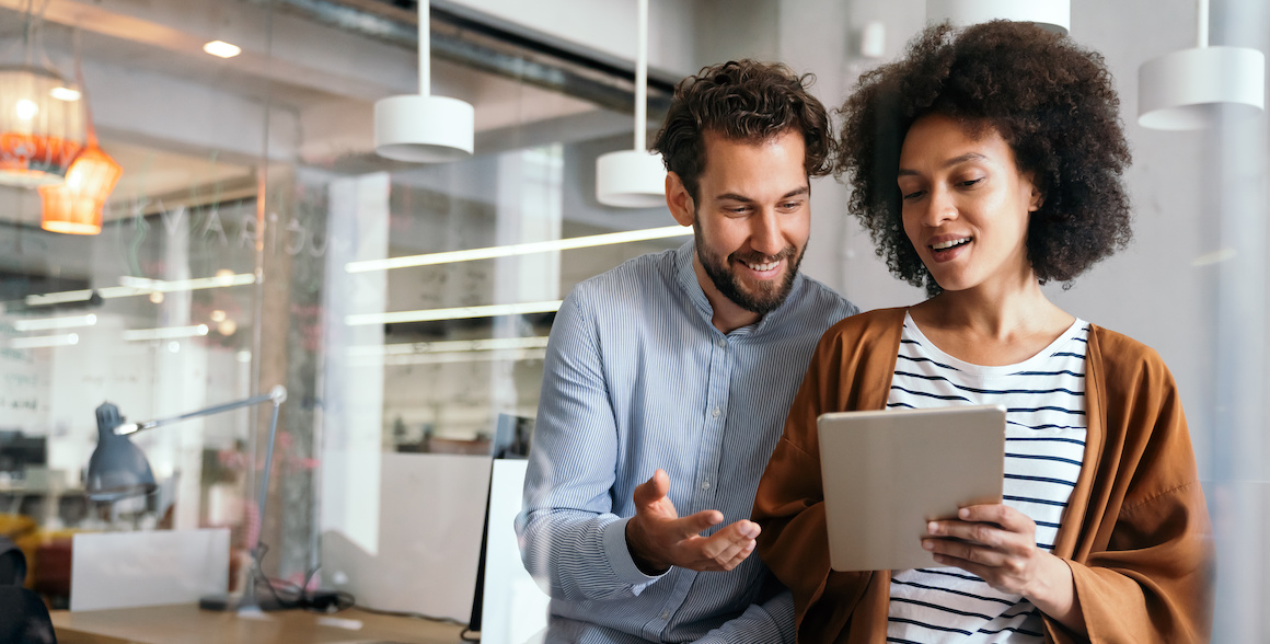 Man and woman looking at budgeting software on tablet