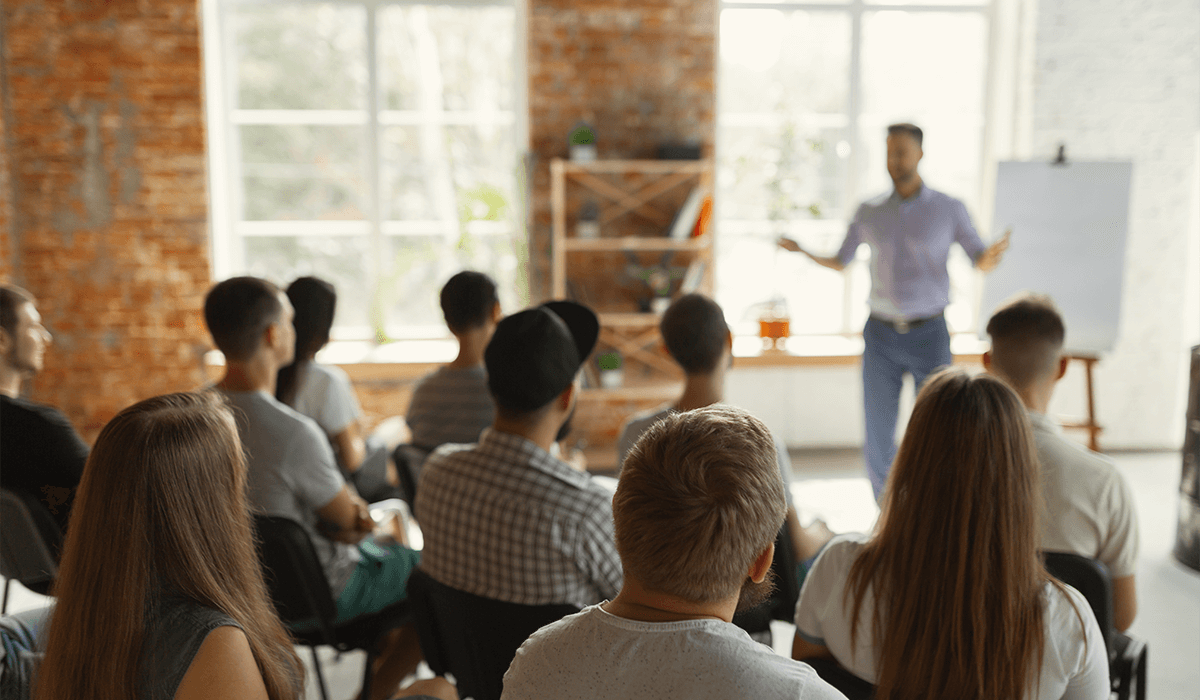 man speaking to a crowd of people